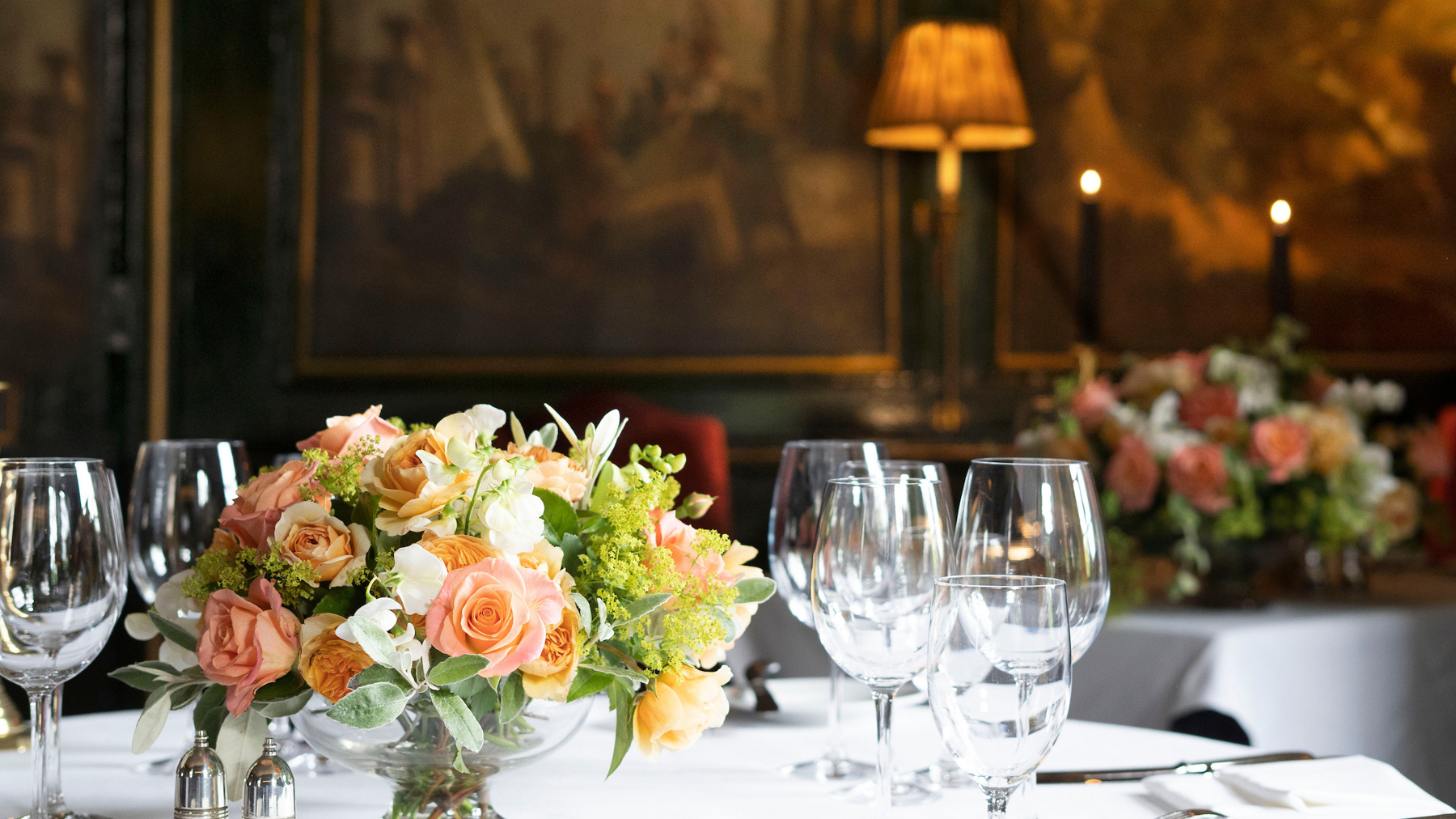 Bouquet of flowers and wine glasses on table with paintings in Edinburgh restaurant private rooms